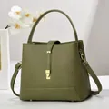 Detail of army green lychee leather bucket bag with golden buckle and sturdy top handle - Green
