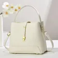 Large off-white pebble leather bucket bag with gold hardware and top handle - Milky White