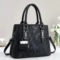 Detalle del bolso tote con textura de mármol negro y colgante de mini monedero - Negro