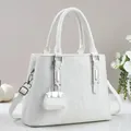 Detalle del bolso tote blanco con textura de rayas verticales y colgante de mini bolso a juego - Blanco Roto