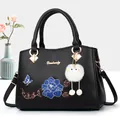 Black faux leather handbag with floral embroidery, butterfly patch and plush toy charm - Black