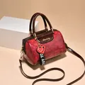 Bolso Boston retro rojo con relieve de cocodrilo, detalles dorados y colgante de corazón - Rojo