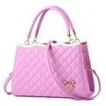 Sac bandoulière matelassé rose avec nœud doré et bandoulière réglable sur fond blanc - Violet Taro