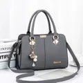 Modische graue Damenhandtasche aus Leder mit Gold-Logo und elegantem Perlenanhänger - Dunkelgrau