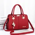 Fashionable red PU leather handbag with lychee pattern and gold floral charm - Burgundy