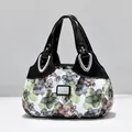 Bolso con estampado floral, ribete de charol negro y detalles metálicos plateados - Negro - Floral Verde Sueño