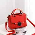 Chic red lychee leather handbag with a sleek golden metal handle and a black magnetic buckle - Red