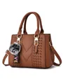 Braune Handtasche aus Kunstleder mit V-Ziernähten und Plüsch-Bommel-Anhänger Detail - Erdgelb