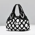Fashionable handbag with black and white circular geometric prints and glossy leather handle - Circle Pattern
