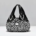 Fashionable leopard print handbag with black patent leather trim and silver hardware - Leopard Print