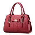 Elegant deep red handbag with geometric triangle texture and gold metallic accents - Burgundy