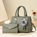 Olivgrünes Handtaschen und Portemonnaie Set aus Leder mit flauschigem Anhänger - Graue Mutter-kind-tasche