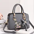 Elegant grey crossbody bag featuring floral embroidery and butterfly pendant for women - Gray