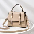 Elegant beige trapezoid crossbody bag with top handle and gold circular metal lock - Khaki