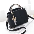 Black litchi-grain leather crossbody bag with golden hardware and hexagonal stitching - Black