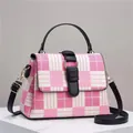 Pink and white checkered crossbody bag with black leather handle and gold hardware - Pink