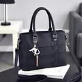 Große schwarze Handtasche mit Litschi-Struktur und goldenem Quastenanhänger für Damen - Schwarz