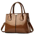 Dark brown patent leather handbag with crocodile pattern and golden metal buckle details - Earthy Yellow