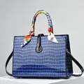 Blue crocodile embossed handbag with black handles and patterned silk scarf detail - Blue