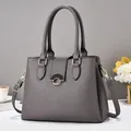 Elegant dark grey textured leather handbag with gold hardware and top handle strap - Gray