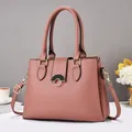 Detail of rose pink tote bag featuring lychee texture leather and gold metal buckle - Pink