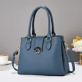 Macro detail of navy blue lychee textured leather bag with gold and black metal lock - Blue