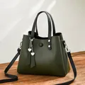 Dark green faux leather trapezoid handbag with black handles and heart charm pendant - Army Green