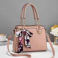 Detailansicht einer rosa Handtasche aus genarbtem Leder mit Kettenriff und Seidenschal - 29*12*21cm / Rosa