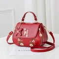 Elegant red faux leather handbag with floral embroidery and pearl H-buckle detail - Burgundy