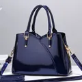 Borsa a mano in vernice blu navy con finitura lucida e accessori in metallo dorato - Blu