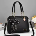 Detail der schwarzen Handtasche aus Leder mit Goldkette und floralem Seidenschal - 29*12*21cm / Schwarz