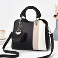 Detail der Farbmix-Lederhandtasche mit gewebtem Griff und passendem Mini-Taschenanhänger - Schwarz