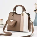 Detail einer zweifarbigen Ledertasche mit geflochtenem Griff und kleinem Münzfach-Anhänger - Khaki
