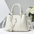 Elegant white lychee leather handbag for women featuring silver padlock and shoulder strap - L29 W12 H21 / White