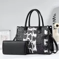 Close-up of black and white crocodile embossed tote bag and matching wallet set - Black