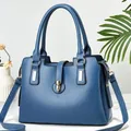 Detailed view of deep blue PU leather handbag with gold hardware and side zipper - Blue