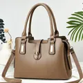 Close-up of mocha brown soft leather handbag with gold metal clasp and adjustable strap - Dark Khaki