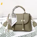Detail of olive green lychee pattern handbag with silk scarf and woven strap decoration - Green