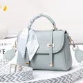 Détail du sac à main en cuir gris avec poignée en soie et large bandoulière - Gris