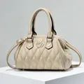 Bolso bandolera beige acolchado con logo de corazón sobre un soporte geométrico - Caqui
