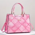 Detail view of pink denim texture and stitched rhombus pattern on a tote handbag - Pink