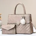 Detail of taupe quilted handbag set with golden hardware and fuzzy pom-pom charm - Khaki