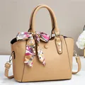Detail der khakifarbenen Leder-Shopper mit Seidenschal und goldenen Metallelementen - Beige