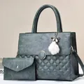 Detail view of teal quilted leather tote bag set with metal ring and plush pompom charm - Green