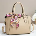Elegant beige pebbled leather tote bag with geometric print silk scarf and gold hardware - Apricot
