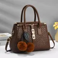 Brown woven texture handbag with dual handles, gold hardware, and furry pompom charm - Coffee