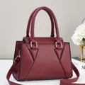 Elegant wine red textured leather tote bag with gold hardware and adjustable strap - Red
