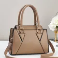 Detail of khaki pebbled leather handbag showing the elegant stitching and golden hardware - Khaki