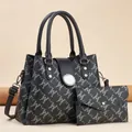 Macro detail of tote bag set featuring grey M-pattern print and silver-tone hardware - Black With Black