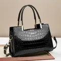 Glossy black crocodile pattern tote bag with gold hardware and adjustable strap - Black